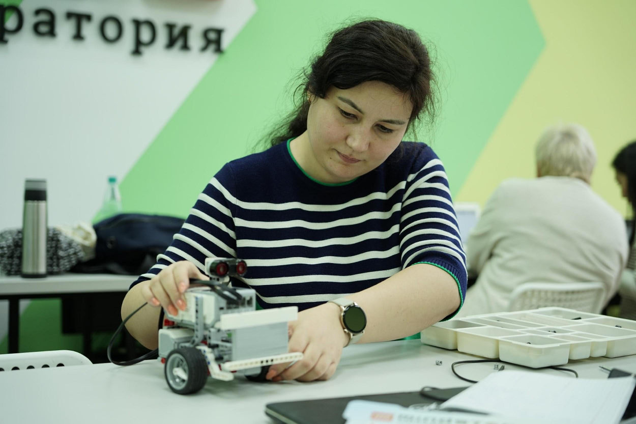 Учитель собирает робота на курсе